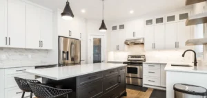 Modern kitchen remodel with white cabinets, stainless steel appliances, and a large island. Hire a professional contractor to remodel your kitchen for a sleek and functional space.