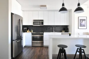 Modern white kitchen with stainless steel appliances and black accents. Plan your kitchen remodel with confidence—hire a professional contractor to help you stay on budget and achieve a beautiful result.