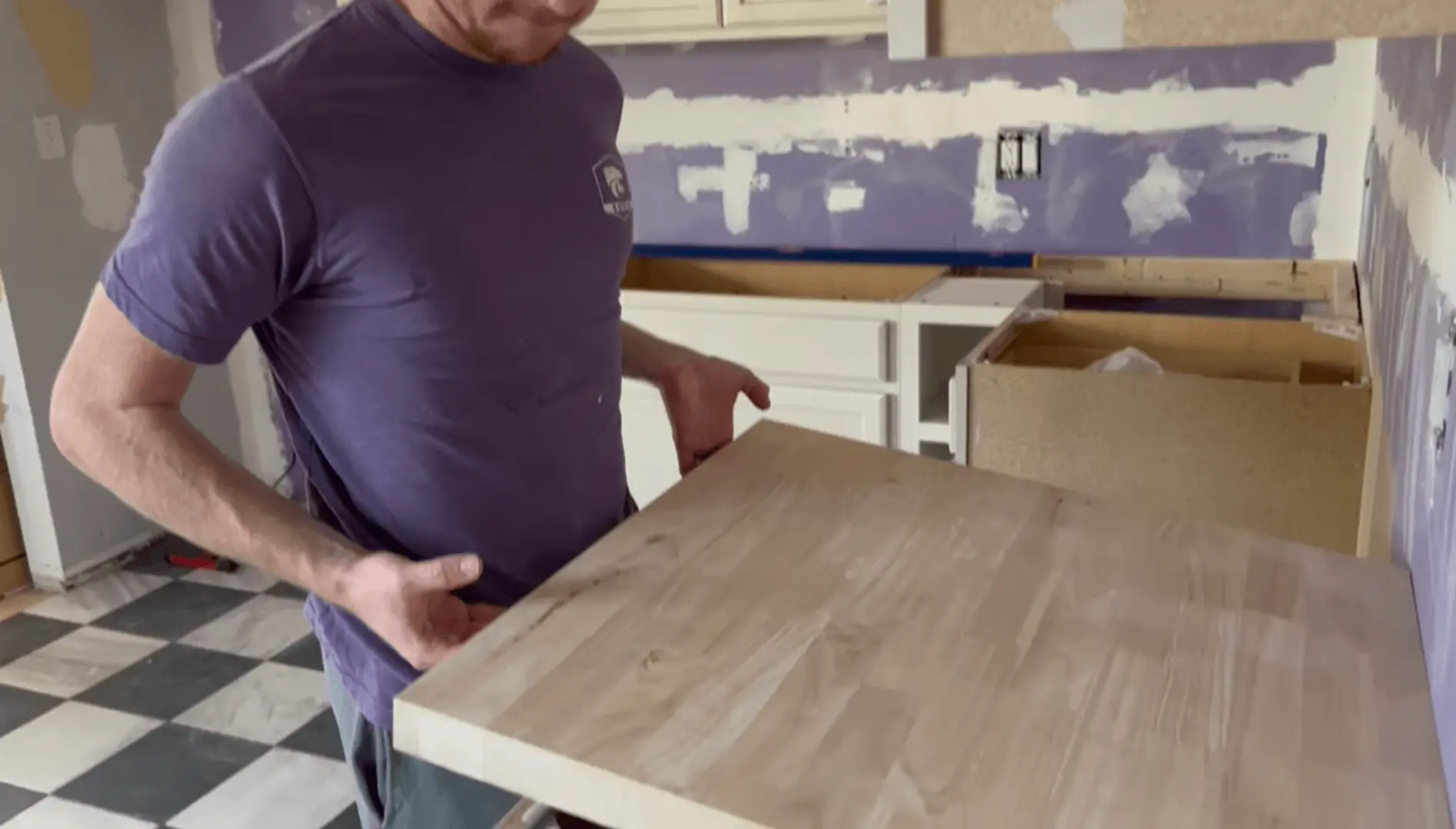 A contractor carefully positions a new countertop during a kitchen remodel. Hire a professional contractor to ensure your remodel is done right the first time.